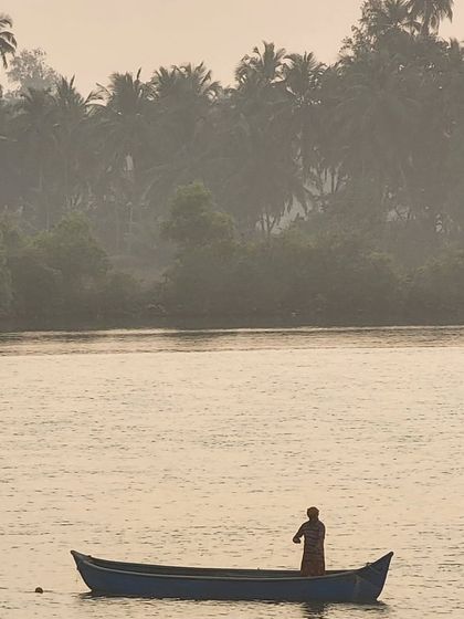 A lone fisherman in his boat on the backwaters. Our coastal routes take you through authentic fishing villages, offering a glimpse into the local way of life.