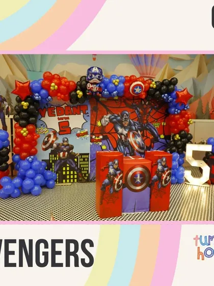 Assemble for an Avengers-themed party! This setup includes Captain America's shield, a Spiderman backdrop, and bold red, blue, and black balloons.