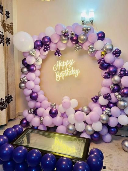 A beautiful birthday ring in shades of purple and silver, with balloons filling the floor for a fun effect.