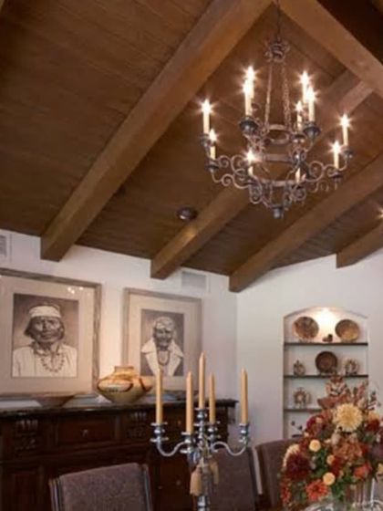 A classic dining room with a vaulted ceiling featuring solid wood beams. This adds a rustic, grand character to the space, showcasing our expertise in traditional wooden structures.
