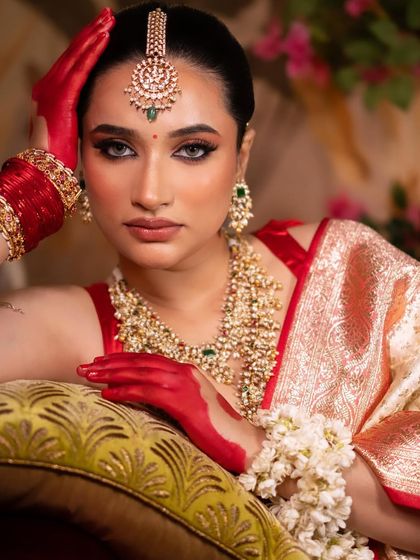 A dramatic and artistic shot of a bride with red-painted hands, her traditional jewellery creating a powerful and memorable image.