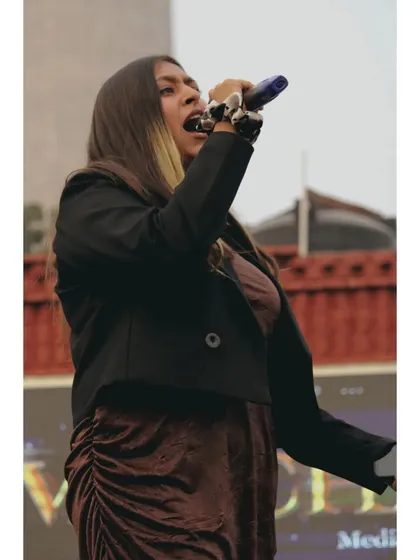 A powerful shot of me singing or speaking passionately on stage. I put my all into every performance to keep the energy high.