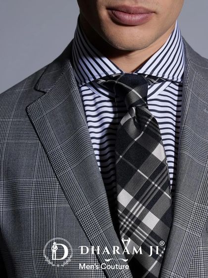 A close-up of a grey plaid suit paired with a striped shirt and a patterned tie. This shows how I help clients master the art of mixing patterns for a sophisticated look.