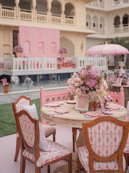 A beautifully set table with custom-printed chairs, ready for guests at the 'Pink Jaipuri Bagh' mehendi.