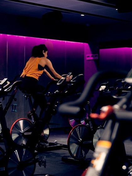 A lone rider in the purple glow of our Indiranagar studio. Sometimes it's just you and the bike.