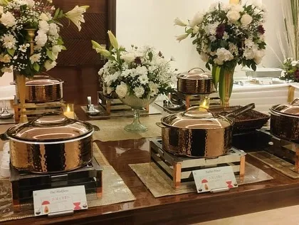 A side view of the anniversary buffet, showing the gleaming copper pots and the thoughtful layout.
