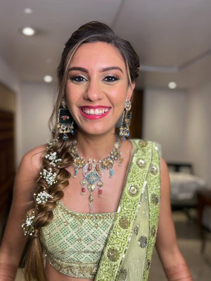 A happy bride showing off her beautiful Mehendi braid. The soft, textured style is perfect for a relaxed and fun event.