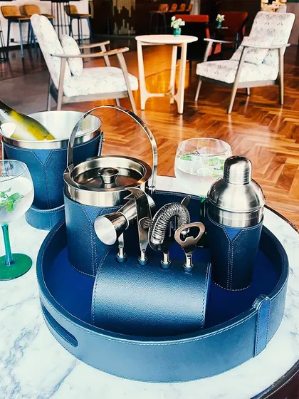 This image displays the full versatility of our Bella Pelle Casa barware. The deep blue leather and metallic accents create a refined and luxurious look, perfect for hosting with style.