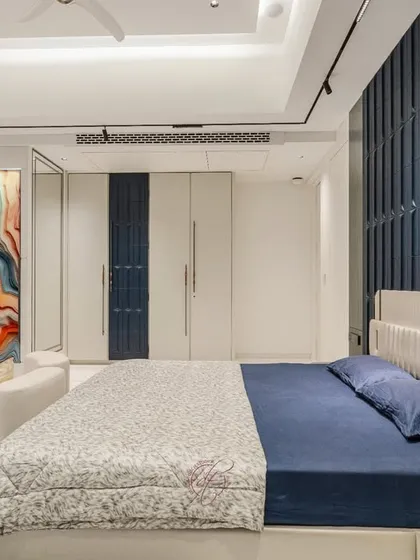 A full view of the blue and white master bedroom, showcasing the spacious layout and luxurious feel. The white marble floors and sophisticated lighting create a bright and airy atmosphere.
