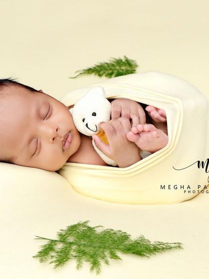 The baby and their little toy, surrounded by greenery. A sweet and natural-looking setup.