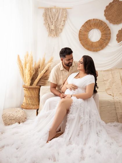 The connection between them is beautifully captured as they gaze at each other. The boho setup provides a warm and intimate backdrop.