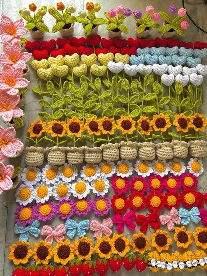 A floor covered in a rainbow of my crochet creations, including rows of colorful stems.