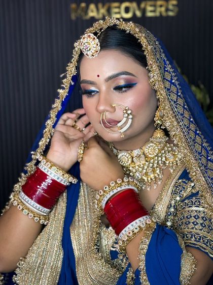 A beautiful shot of the Rajputi bride adjusting her earring, highlighting her stunning jewelry and makeup.