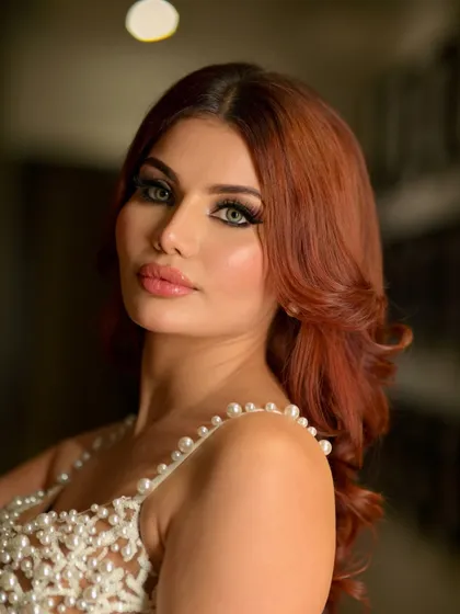 Cocktail ready with a bold, winged eyeliner and a perfectly contoured face. This look is all about high-fashion glamour, completed with voluminous red hair for a dramatic effect.