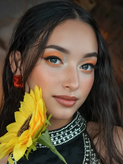 Another angle of the sunflower look, showing the seamless blend of the orange eyeshadow and the glowing, sun-kissed skin.