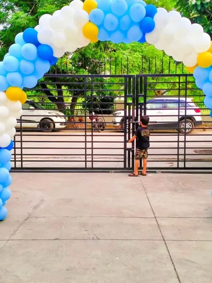 A classic blue and white balloon arch at the entrance of a home for a Kuan Pujan ceremony, creating a simple and festive welcome.