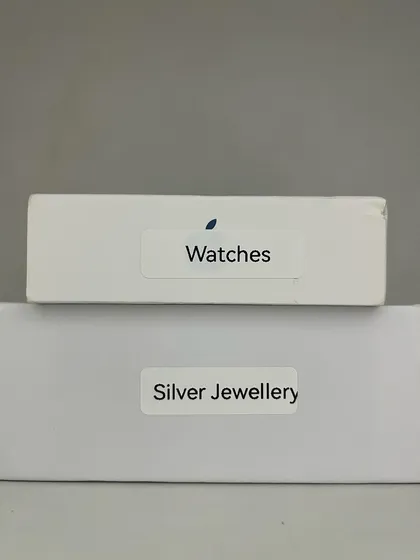 You don't always need to buy new containers. I encourage clients to reuse packaging and delivery boxes for storage. A simple label turns a basic cardboard box into a custom organizer for watches or jewelry, saving money and reducing waste.