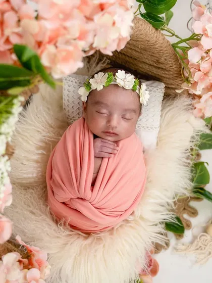 Nestled in a wreath of soft pink flowers, this sleeping baby looks like a dream. Floral arrangements are one of my favorite ways to add a touch of romance and delicacy to a newborn girl setup.