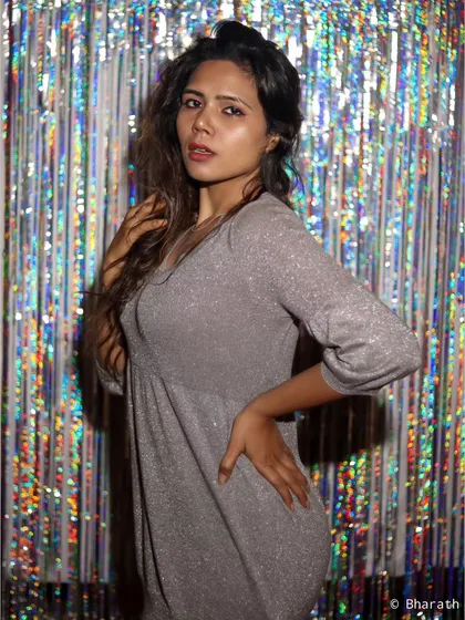 A three-quarter portrait of the model in the silver dress, with a direct and engaging gaze.