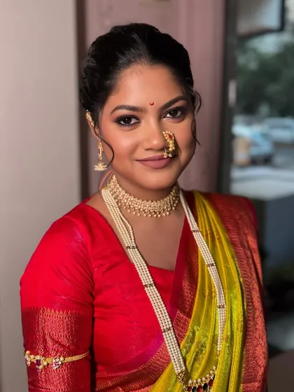 A beautiful Maharashtrian bride, Karishma. Her look features the traditional pearl jewelry and a vibrant saree, paired with makeup that is both classic and radiant.