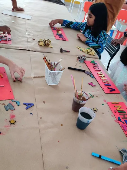 Another angle of the nameplate-making party, showing the kids choosing letters and embellishments for their unique creations.