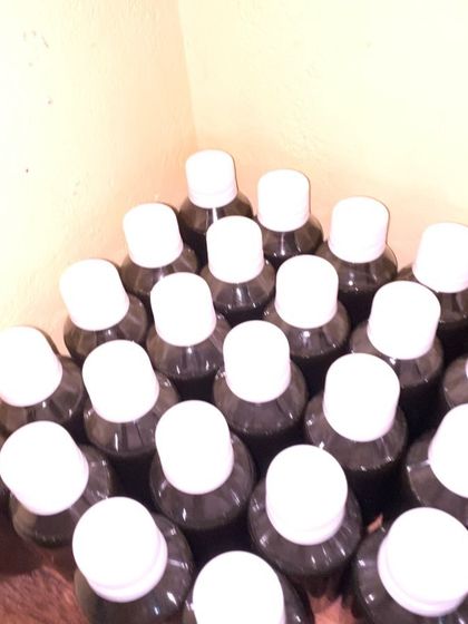 A top-down view of a batch of Kanya Hair Oil bottles, showing the care I put into my production.