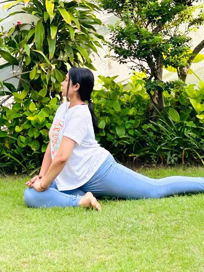 Eka Pada Rajakapotasana (Pigeon Pose) in the grass. This hip-opening pose feels even more grounding when practiced in direct contact with the earth.