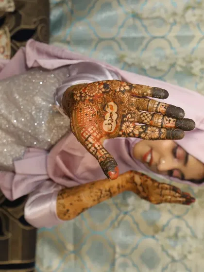 Another shot of my bride Taskeen, giving a closer look at the detailed henna on her palm, which includes personalized elements.