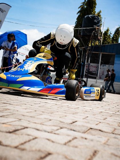 A driver gets ready to push his kart onto the grid.