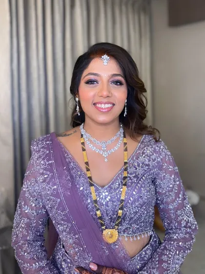 A smiling portrait of the reception bride. Her diamond jewelry and cool-toned makeup create a chic and modern look.