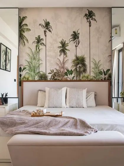 This bedroom is designed as a personal sanctuary. The tropical-themed wallpaper creates a focal point and a sense of escape, while the neutral color palette, clean lines, and soft textures make the room feel calm and restful.