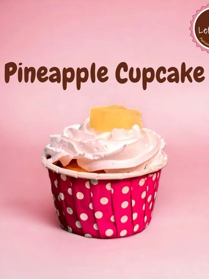 A refreshing Pineapple Cupcake. This treat features a light vanilla sponge topped with a swirl of pineapple-flavored cream and a small piece of candied pineapple.