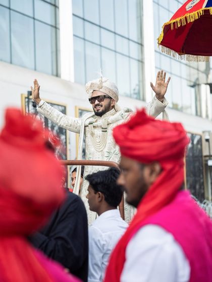 The groom enjoying his baraat procession, waving to his family and friends.