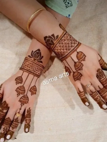 This design features elegant hanging jhumkas (earrings) and lotus motifs. It's a very graceful and feminine design, perfect for any festive party.