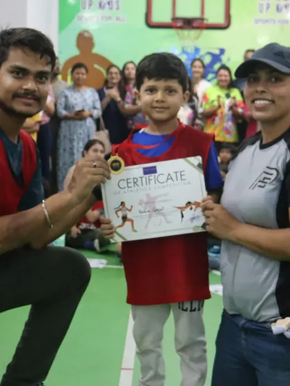 A coach presents a medal and certificate to a deserving young athlete.