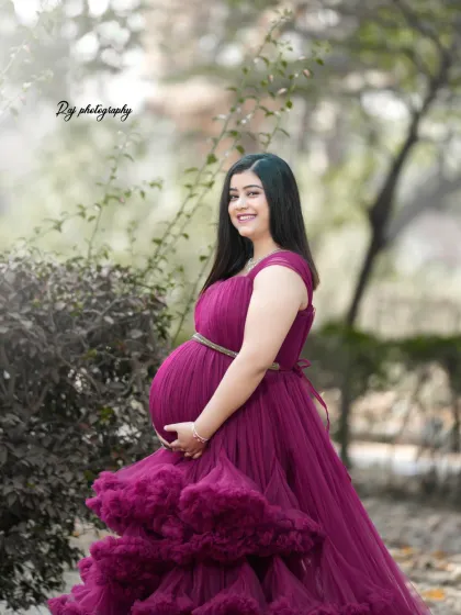 A beautiful solo portrait in a wine-colored ruffled gown, set against a backdrop of trees with autumn leaves.