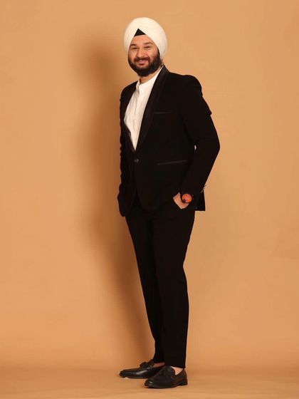 A classic black tuxedo is a wardrobe essential. Here, a model showcases our sharp, well-fitted black suit, perfect for any formal occasion.