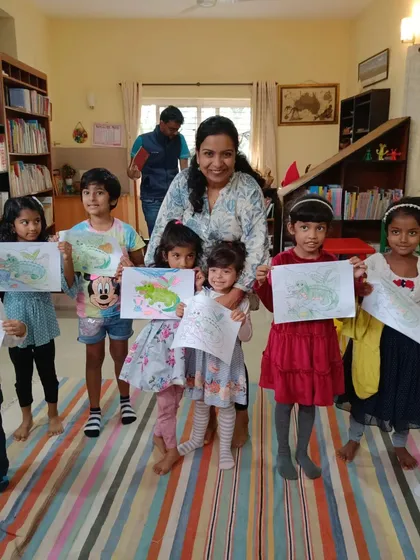 The finished ghariyal drawings are held up for a proud group photo with the storyteller.