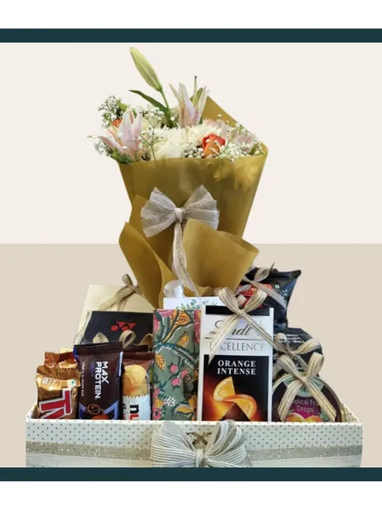 This luxe gourmet-floral anniversary hamper is designed to impress. It combines a stunning bouquet of fresh lilies with a curated selection of premium chocolates and snacks.