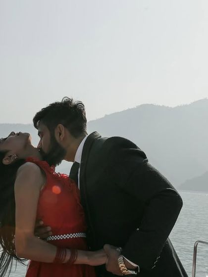 A passionate kiss on the neck while on the boat, capturing a moment of pure intimacy and romance against the hazy mountain backdrop.