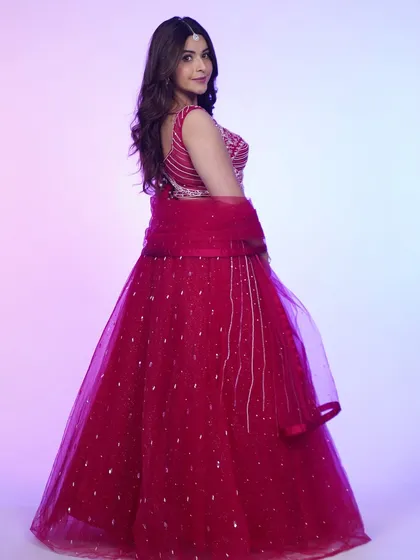 A back view of the hot pink lehenga, showcasing the delicate tie-up detail and the sheer dupatta.