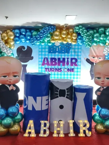 The complete Boss Baby first birthday stage, with character cutouts, themed props, and marquee letters spelling the baby's name.