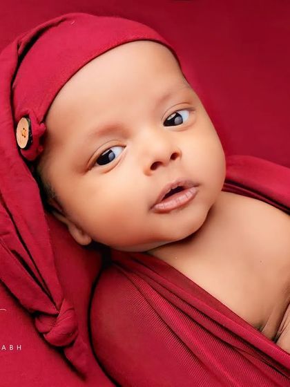 A beautiful, calm portrait of an awake newborn looking directly into the lens.