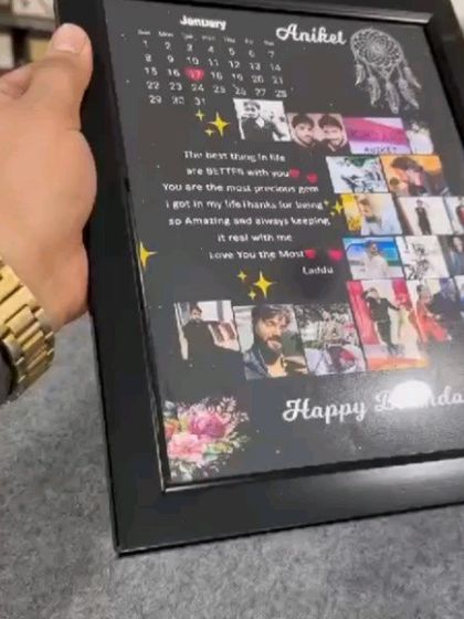 A closer look at the custom birthday frame, held to show the quality and matte lamination finish. The design includes a calendar, a heartfelt message, and a collage of pictures.