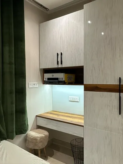 Here, I designed a compact study nook integrated with a floor-to-ceiling wardrobe. The use of contrasting wood and white laminate finishes, along with under-cabinet lighting, defines the workspace and makes it feel intentional.