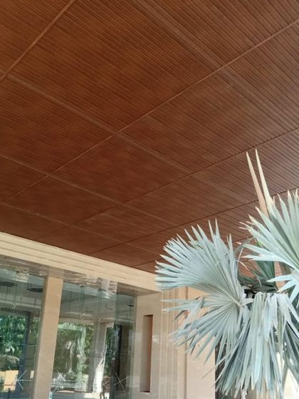 A simple yet elegant wood-finish ceiling in a grid pattern. This classic design is versatile and adds a sense of order and warmth to any outdoor porch or entrance.