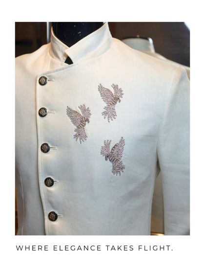 A closer view of the white bandhgala, showing the texture of the fabric and the sparkle of the sequined bird embroidery. This is where elegance takes flight.