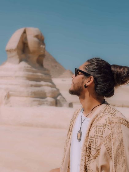 A contemplative portrait with the Great Sphinx of Giza. The profile view creates a sense of awe and connection with the ancient monument.