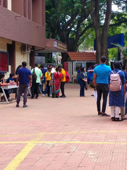A wide shot of the job fair, with volunteers assisting candidates at the registration desk. Our goal is to create a seamless and supportive environment.