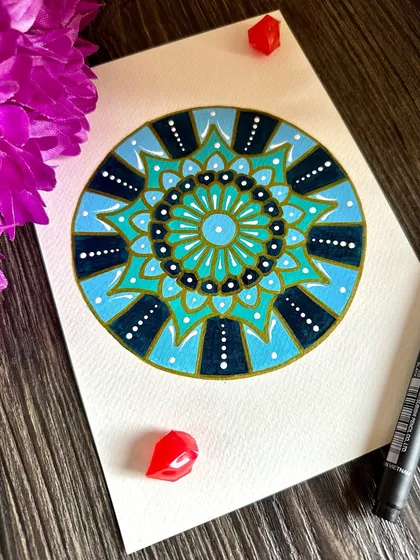 This mandala uses shades of blue and teal to create a calming, ocean-like feel. The simple patterns and soothing colors make it a perfect piece for finding a moment of peace.
